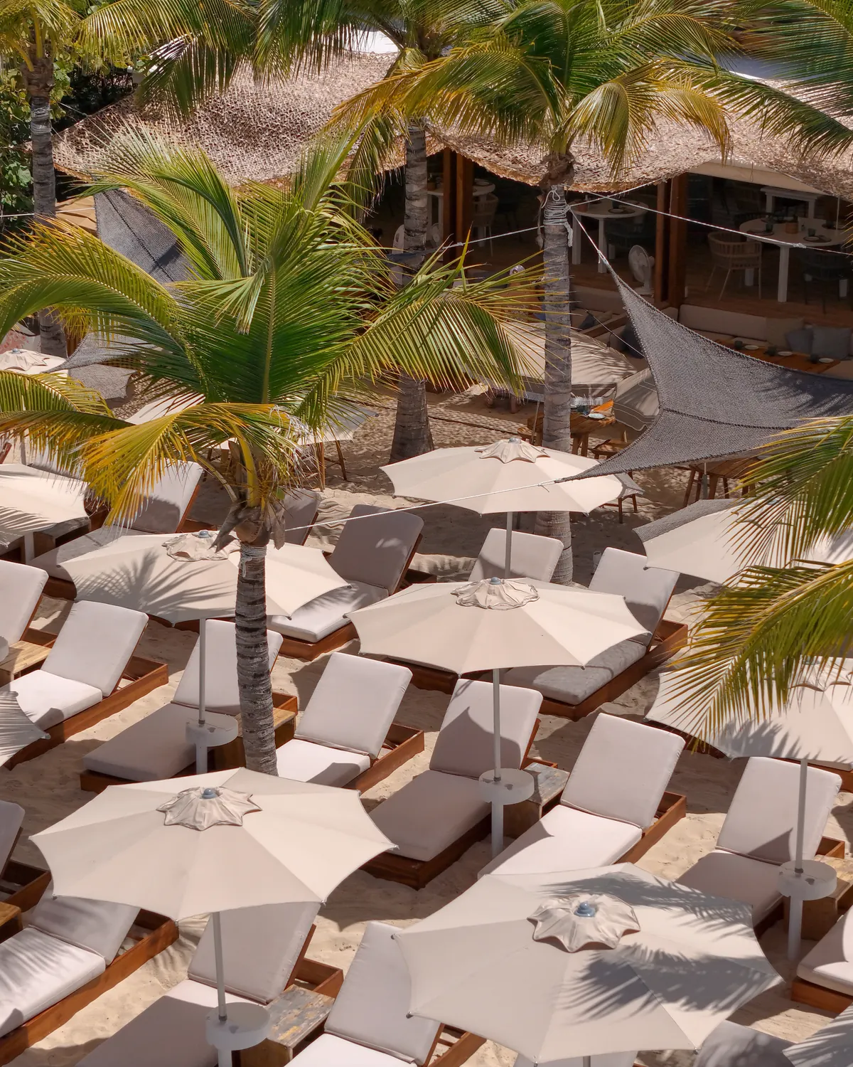 Wide view of the Kalatua restaurant terrace opening onto Mullet Bay beach