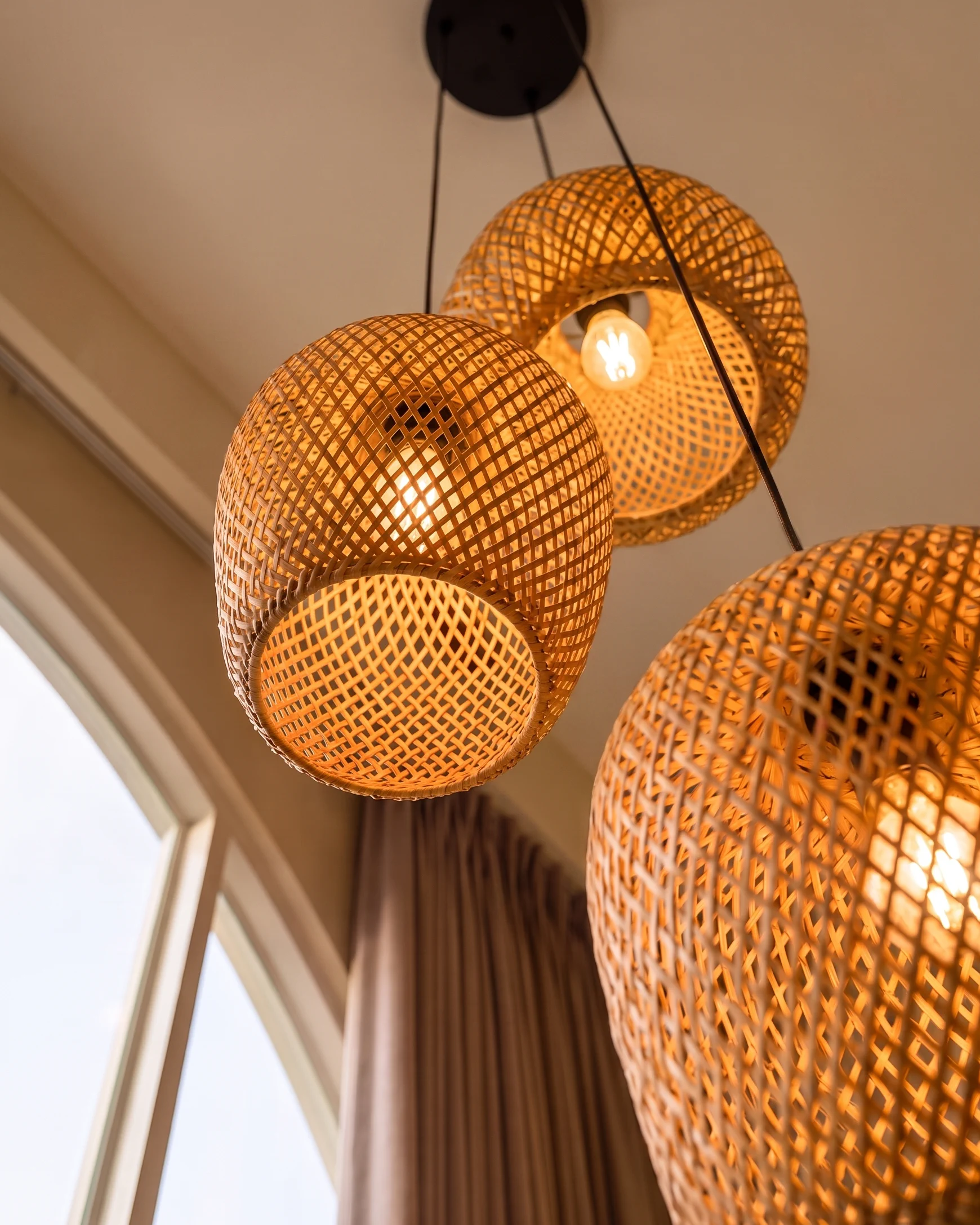 Rattan pendant lights above the Villa Mares staircase in warm evening light
