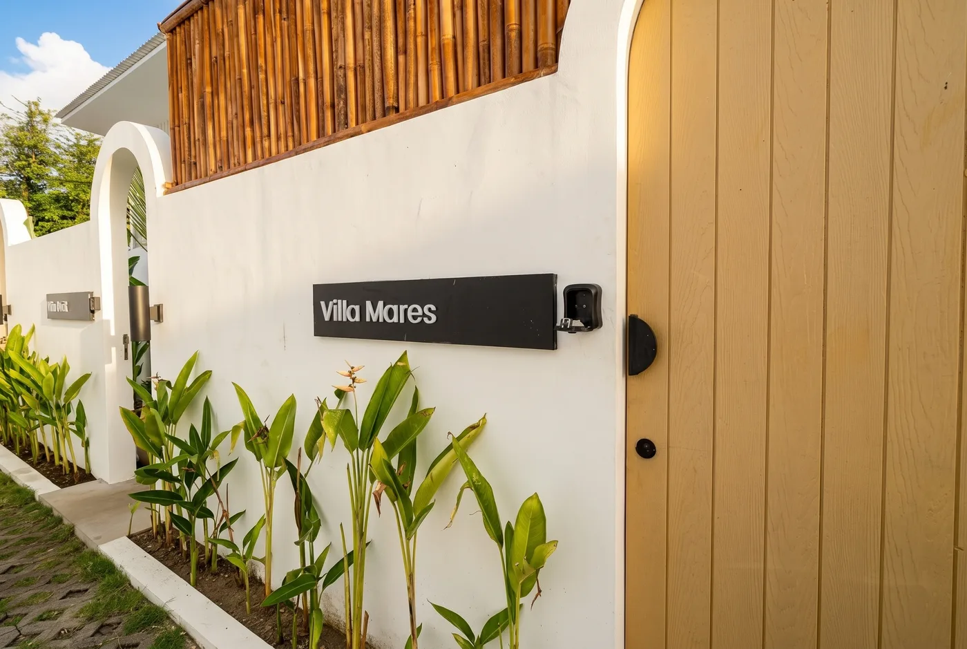 Villa Mares entrance gate with wood door and villa nameplate signage, Bali
