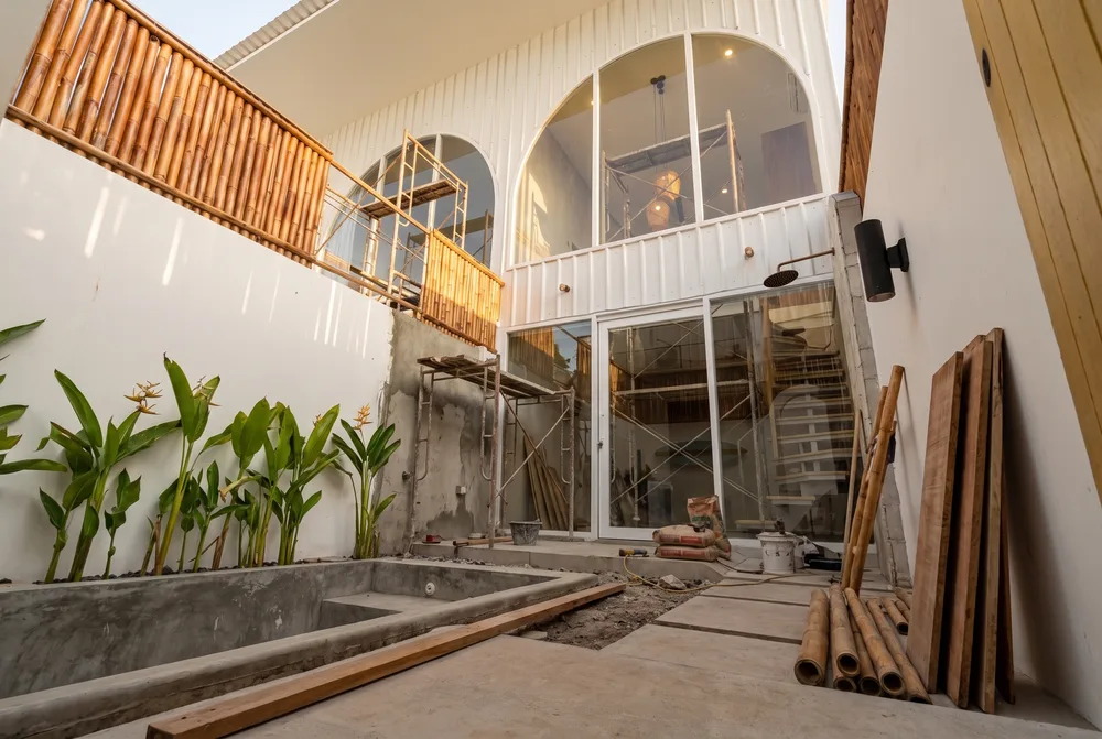Villa Mares pool courtyard during construction, showing the concrete pool shell and bamboo scaffolding